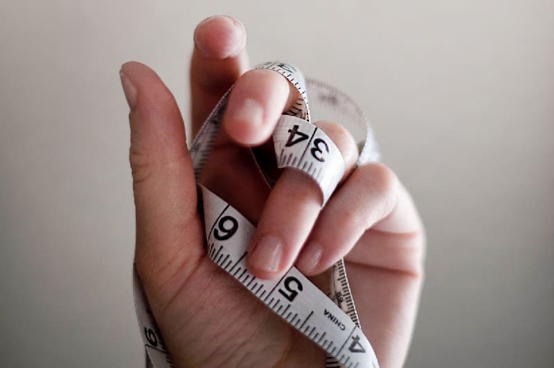 Hand with measuring tape around it emphasizing measuring strategic priorities